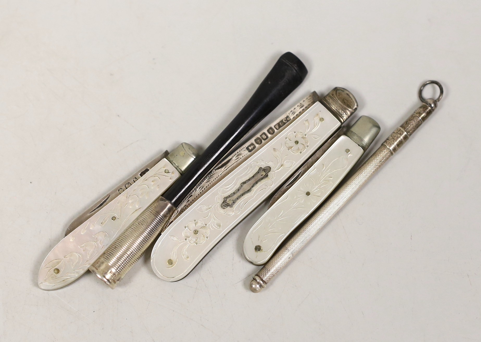 Three assorted mother of pearl mounted silver fruit knives, largest 82mm, a cigarette holder and a swizzle stick.